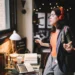 Young Latinx woman sitting at the desk in her Los Angeles apartment, receiving happy news over the social networks or just having a nice day, dancing to the music.