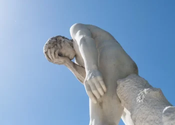 Man facepalming statue under the sun in the Tuileries garden.